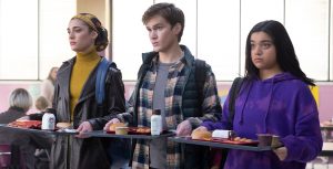 (From Left to Right) Yasmeen Fletcher as Nakia, Matt Lintz as Bruno, and Iman Vellani as Kamala Khan stand with their lunch on trays in their high school cafeteria