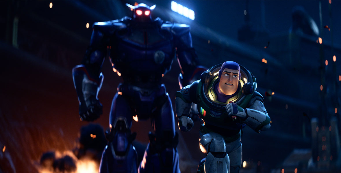 In an image from Disney and Pixar’s Lightyear, Buzz is running away from the ominous Zurg, who is looming over him in the background. He is wearing his iconic Space Ranger spacesuit. 