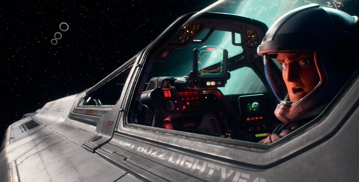 In a still from Disney and Pixar’s Lightyear, Buzz is seen in the cockpit of a spaceship, looking behind him at something off camera. There are lots of gizmos seen in front of him in said cockpit, and some sort of planet can be seen through the window to his right. Three circles can be seen in space in front of him, as well as stars.