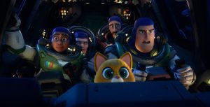 In a still from Disney and Pixar’s Lightyear, Izzy, Darby, Mo, Buzz, and Sox are in the cockpit of a spaceship. The humans are wearing spacesuits; all look concerned. Knobs and buttons are lit up around them.