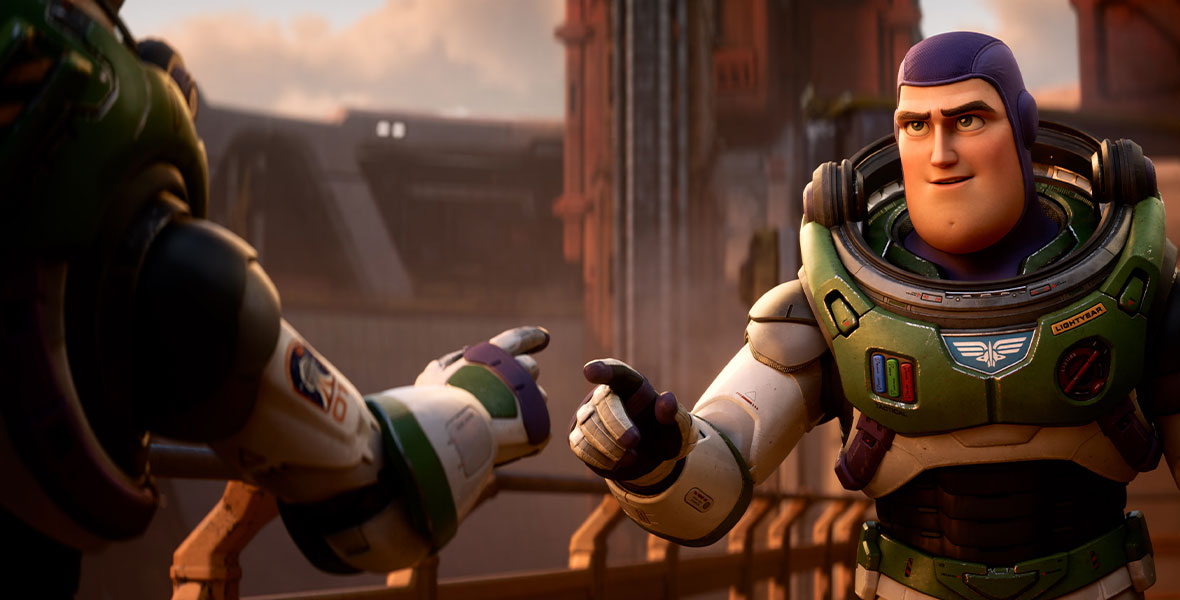 Buzz, wearing his Space Ranger spacesuit, is seen pointing his index finger towards someone seen a little off camera and to the left, in a still from Disney and Pixar’s Lightyear. They are standing on a metal gangway.