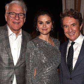 Left to right: Disney Legend Steve Martin, wearing a grey plaid suit jacket; Selena Gomez, wearing a sparkly silver evening gown; and Martin Short, wearing a dark grey suit, standing together at the premiere of Hulu’s Only Murders in the Building season 2.