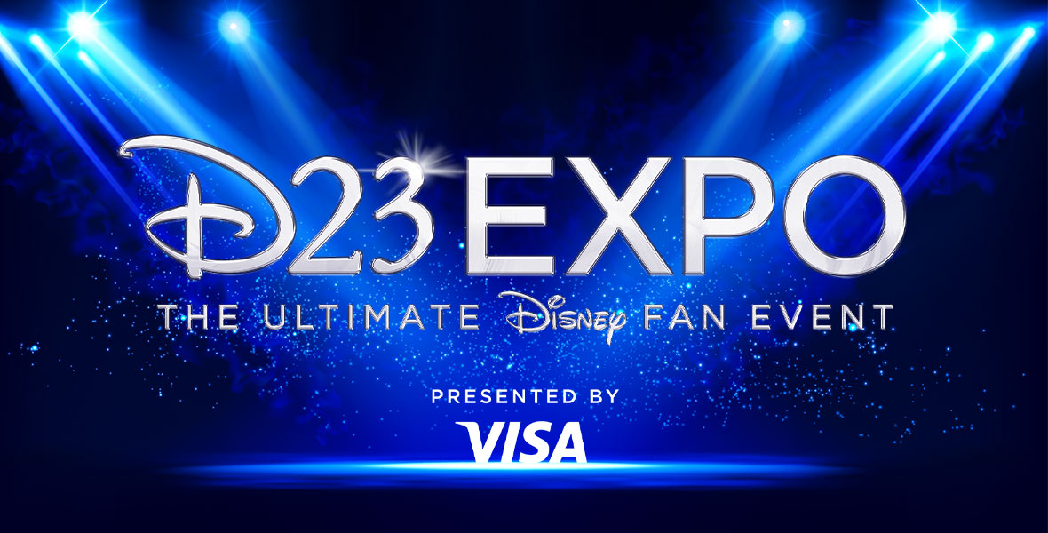 The logo for D23 Expo: The Ultimate Disney Fan Event, Presented by Visa floats over a dark blue stage lit by light blue spotlights and glitter floating in the air.