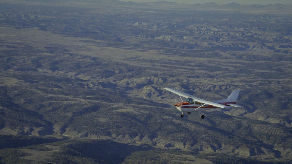 In a scene from National Geographic’s America the Beautiful on Disney+, a plane flies over the rolling plains of Montana, surveying suitable land for rewilding animals as part of the American Prairie Reserve project.
