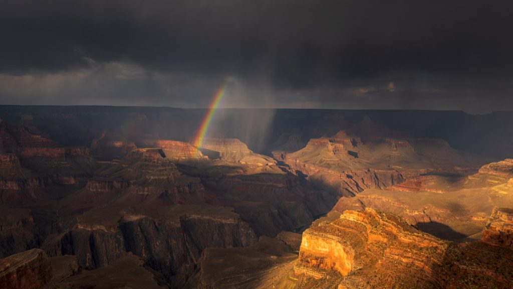 In a scene from National Geographic’s America the Beautiful on Disney+, a rainbow forms above the Grand Canyon, Arizona, during a monsoon storm.