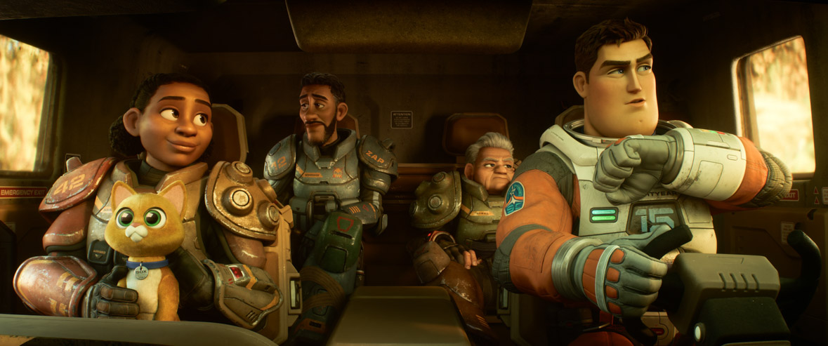 From left to right: In the passenger seat, Izzy is holding Sox the cat robot companion and looking at Buzz; behind her, Mo and Darby are looking out the windows; and Buzz is piloting the vehicle while talking into a communicator on his wrist, in a still from Disney and Pixar’s Lightyear. They are all wearing spacesuits, except Sox.