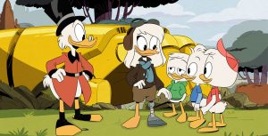 Della Duck stands in aviator gear, outside her rocket. Her right leg is a prosthetic she made out of rocket materials so she could get home from her mission to the moon. Her three duckling sons stand to her right with pleased expressions, while Scrooge McDuck stands to the left.