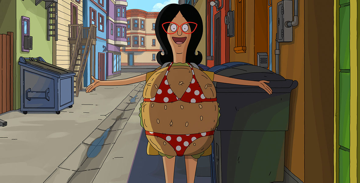 Linda Belcher from The Bob’s Burgers Movie wears a burger costume with a red bikini with white polka dots on top.