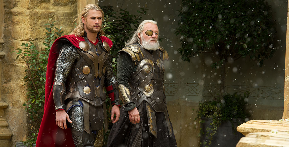 (L-R) Chris Hemsworth as Thor and Anthony Hopkins as Odin walk through a courtyard in an Asgardian palace in Marvel Studios’ Thor: The Dark World, as flurries fall to the ground.