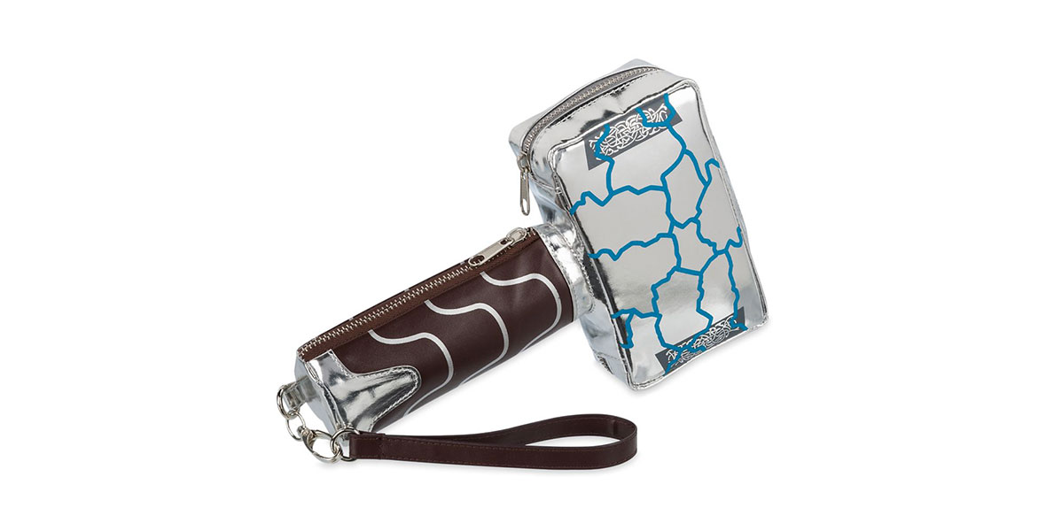A wristlet purse designed to look like the rebuilt hammer, Mjolnir. The wristlet has a silver zipper pouch designed like the head of the hammer, with blue cracks across it. The brown handle of the hammer has a second zip pouch and an attached wrist strap.