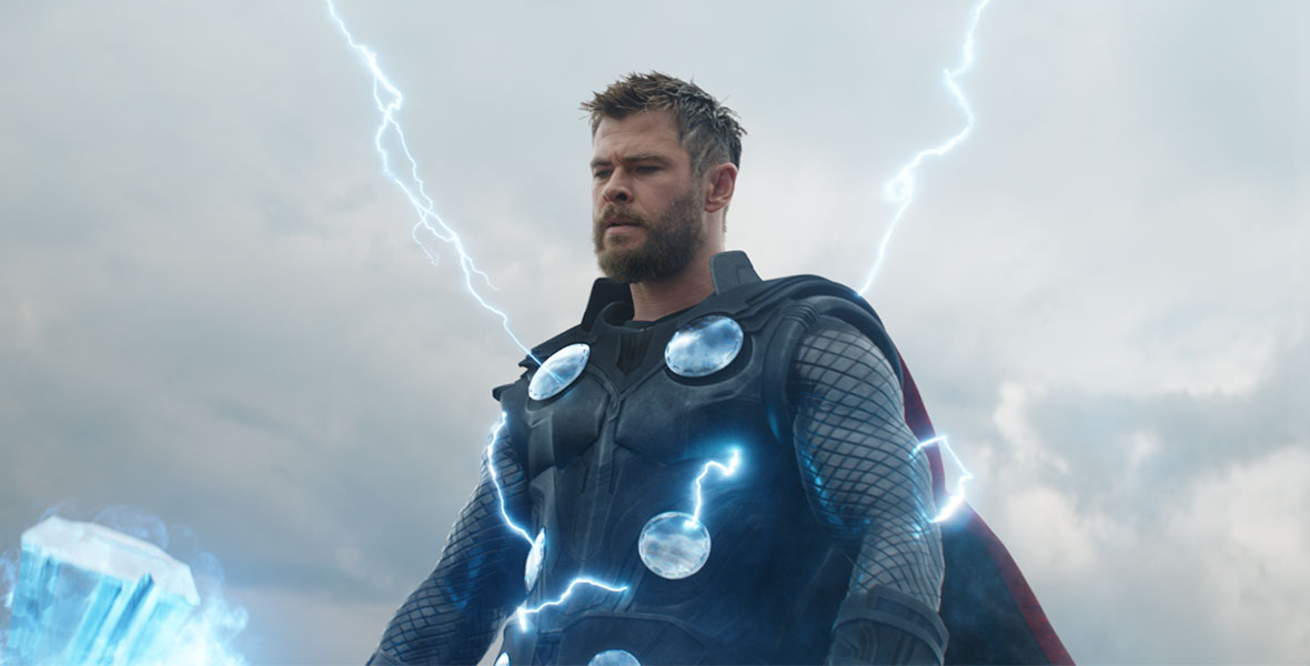 Thor stands in dark, steel armor as blue lighting shoots through his body.