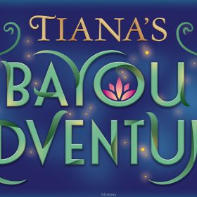 The logo for Tiana’s Bayou Adventure, featuring the attraction name in gold and green curly text on a blue background. A pink flower blooms in the “o” of Bayou, and small fireflies dot the area around the text.