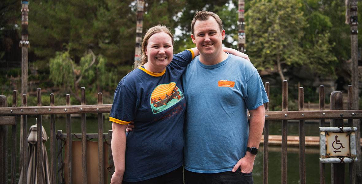 Disneyland cast members Katherine Smissen and her husband Garrett Gordon stand smiling on the dock with their arms around one another after competing in time trials for the Disneyland Resort Canoe Races.