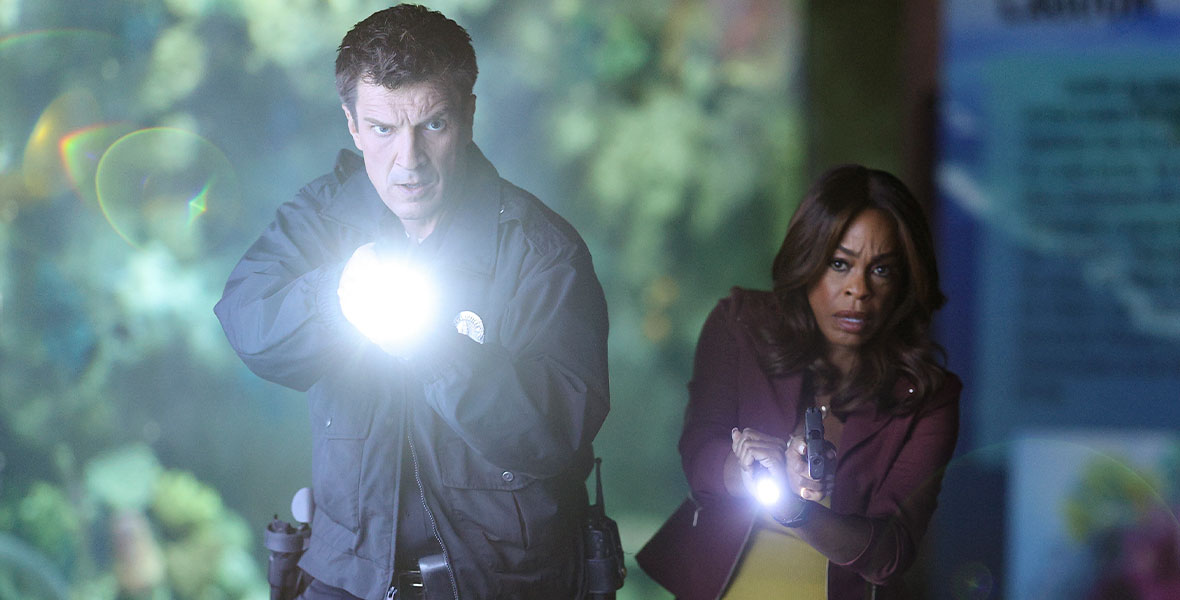 Nathan Fillion and Niecy Nash-Betts draw their guns and shine their flashlights in a tense scene from The Rookie.