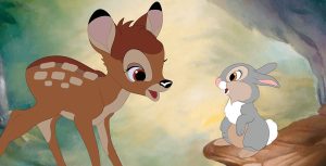 Bambi stands between Thumper (left) and Flower (right) in a field of pastel flowers. Bambi is a fawn and has medium brown hair with lighter spots and a black nose. Thumper is a rabbit with a light gray coat with brown and white spots. Flower is a black and white skunk with big blue eyes.