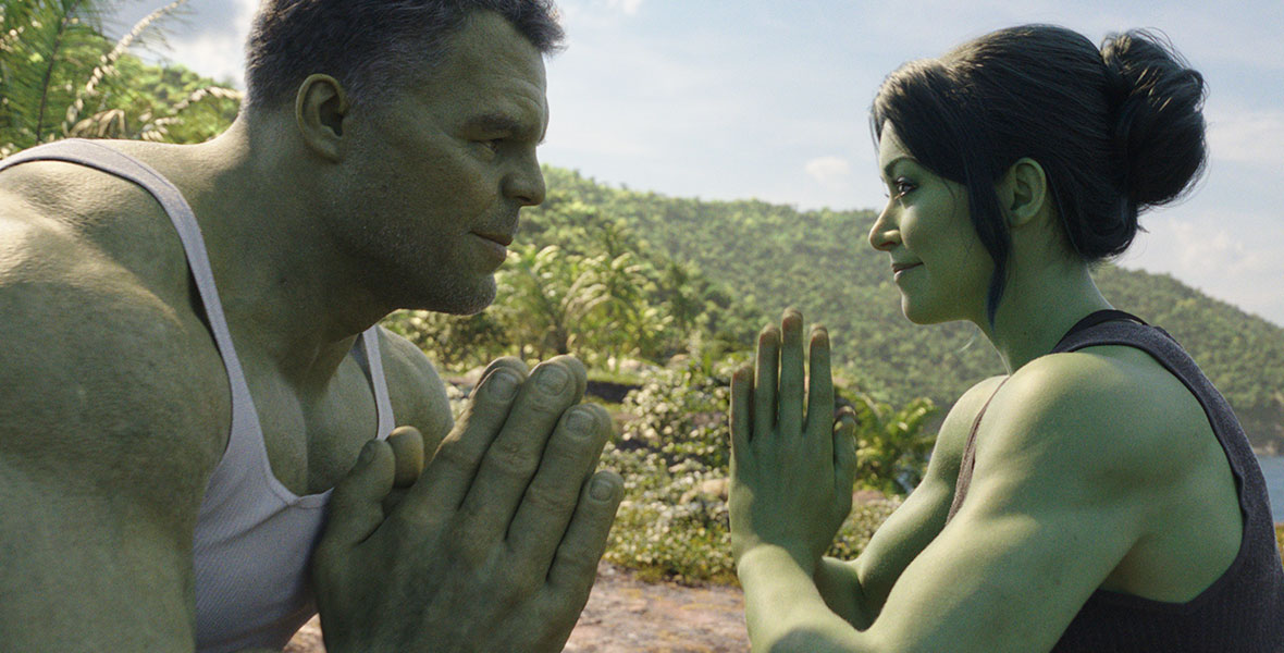 Actor Mark Ruffalo portraying Bruce Banner/Hulk with CGI green skin and hair wears a white tank top and folds his hands in a prayer position. Actor Tatiana Maslany portraying Jennifer Walters/She-Hulk with CGI green skin and hair wears a dark gray tank top and folds her hands in a prayer position facing Ruffalo. Both are standing on a tropical beach with sand, ocean, and lushy foliage behind them.
