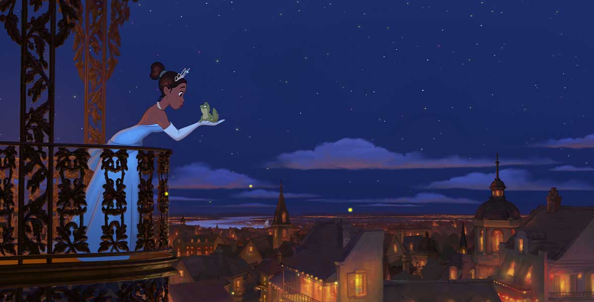 Tiana wears a blue ballgown with matching gloves and a tiara. She stands on a balcony and leans to kiss the frog she is holding. A nighttime skyline of New Orleans is to the right of the frame.