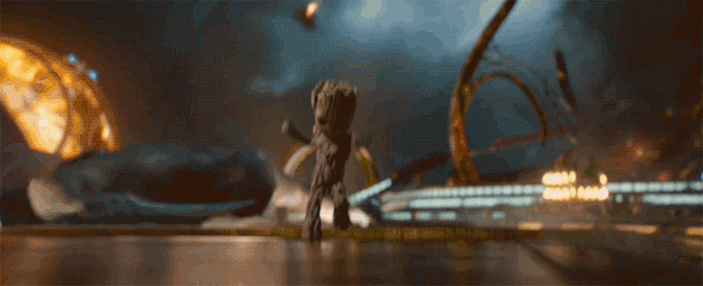 A gif of Baby Groot from Guardians of the Galaxy Vol.2. Baby Groot is dancing and getting really into some music as a battle happens behind him. A large tentacle monster thrashes Drax around behind him, but he pays no attention to it and keeps on grooving.
