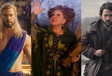 Thor, played by Chris Hemsworth, is shirtless and wearing a blue Grecian robe. Winifred Sanderson, played by Disney Legend Bette Midler, is wearing her green and purple dress and raising one hand in the air, and in the other hand, she holds her magical book of specials. Cassian Andor, played by Diego Luna, walks with purpose.