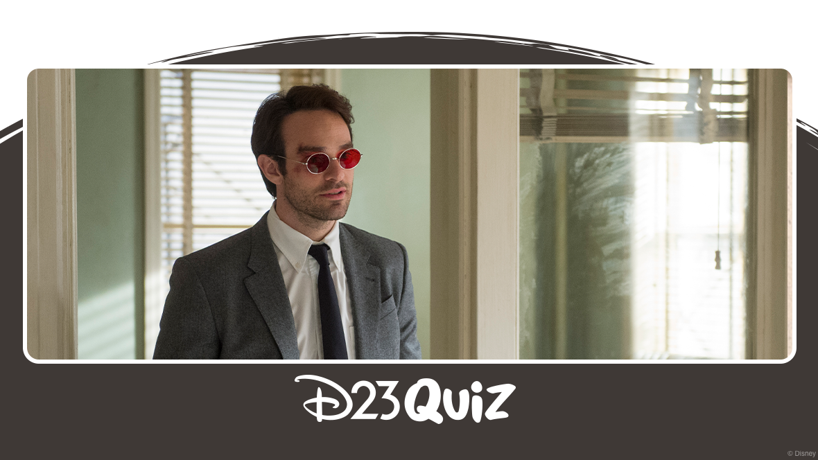 Matt Murdock (Charlie Cox) stands a doorway of an office. He&rsquo;s wearing a grey suit and red-tinted glasses.