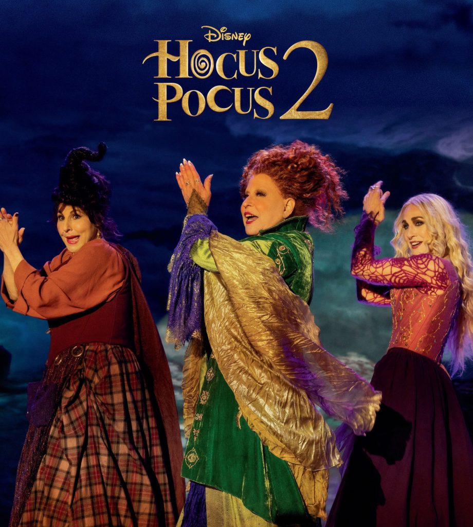The back cover of Disney twenty-three, featuring Mary, Winnifred, and Sarah Sanderson hold their hands up in a similar clapping dance motion, appearing to be mid-musical performance against a purple, foggy landscape with the Hocus Pocus 2 logo above them.