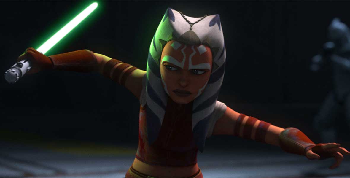 The animated Star Wars character Ahsoka Tano wields a green lightsaber in her right hand. A Togruta, she has large montrals, head tails, and white facial pigments.