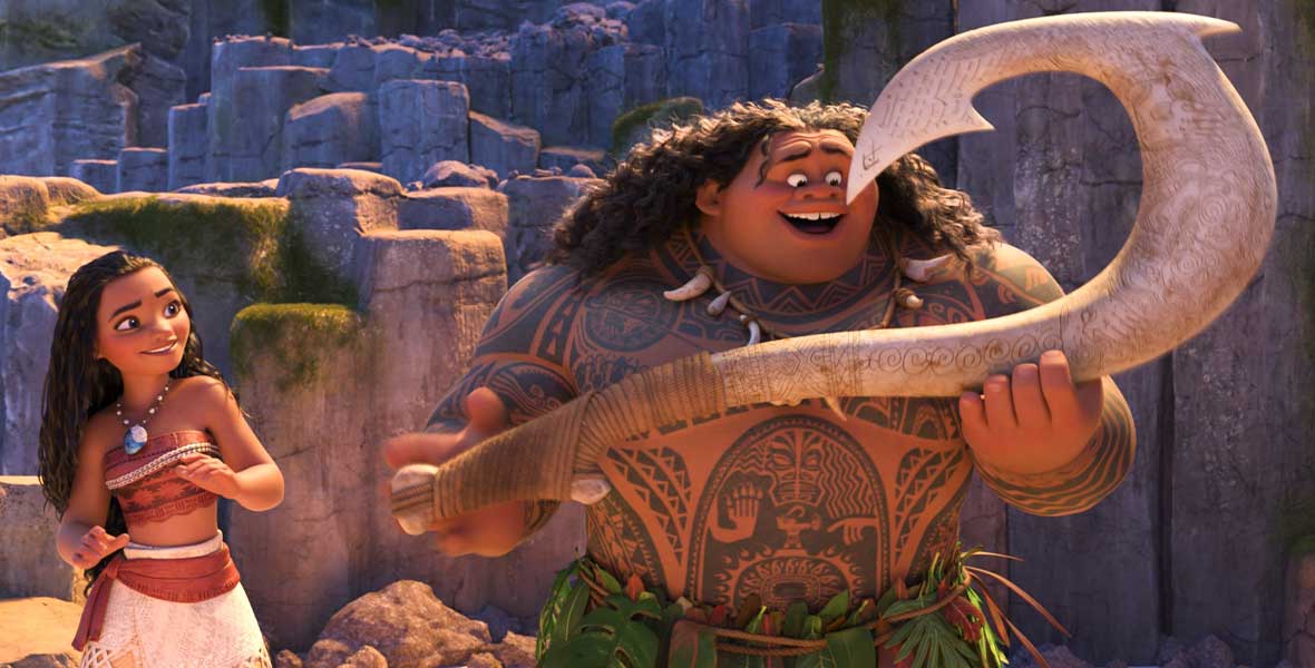 Animated teenage girl Moana leans and smiles while looking at Maui. She wears an orange and tan strapless top, a shell necklace, and a tan skirt. Maui stands to her left and holds a large hook. He is shirtless but wears a grass skirt and his body is covered in tattoos.