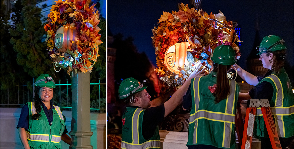 A woman wears a black shirt, green work vest, and green helmet. She stands next to a cement pole adorned with a large wreath with fall leaves and orange pumpkin. Three adults stand around a tall cement pole as they hang a large fall wreath. They wear black shirts and green work vests along with green helmets. 