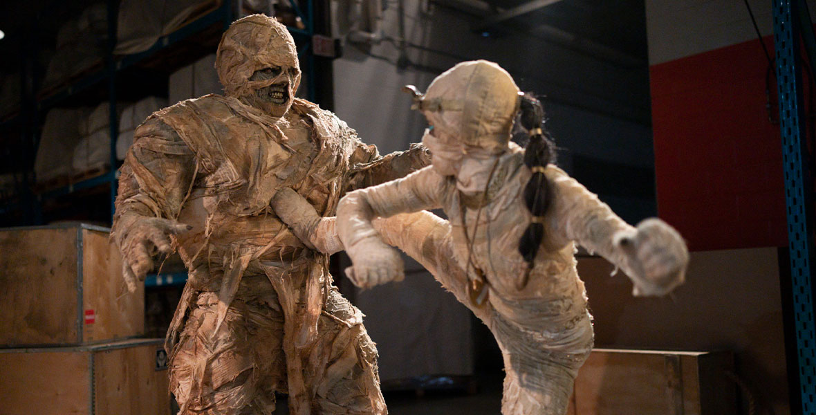 (From left to right): T.J. Storm, in character as the mummy Sobek, stands strong as he is kicked in the chest by Rryla McIntosh, in character as the mummy Rose.