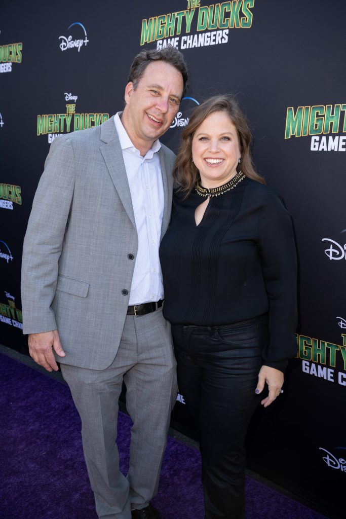 Showrunners and executive producers Josh Goldsmith and Cathy Yuspa pose on the purple carpet at the premiere event for The Mighty Ducks: Game Changers