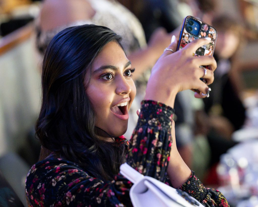 Actor Swayam Bhatia cheers and takes a photo on her cell phone during the premiere event for the second season at Honda Center in Anaheim, California.