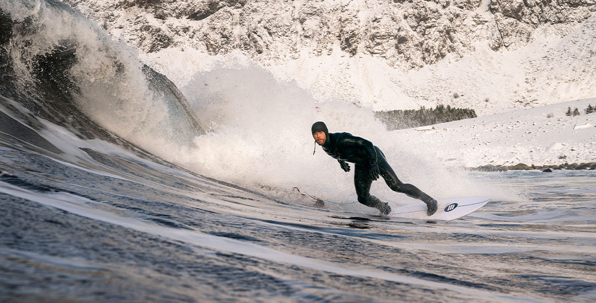 Chris Hemsworth wears a wetsuit as he surfs a massive wave.