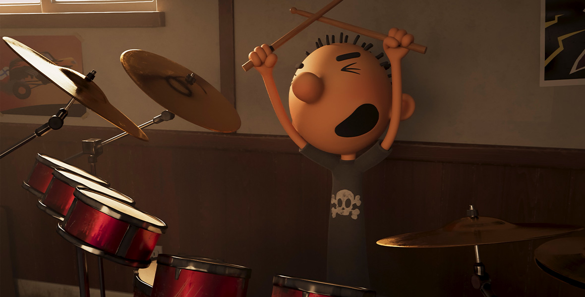  In a scene from the animated film Diary of a Wimpy Kid: Rodrick Rules, Rodrick, a teenage boy, sits at a red drum set and holds wooden drumsticks crossed above his head. Rodrick wears a black T-shirt with white skull and crossbones printed on the front of his shirt. Behind Rodrick is a white wall and wooden baseboards. A colorful poster with a monster truck hangs on the wall to the right of Rodrick.