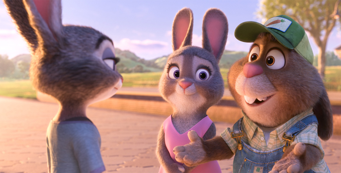Judy, a bunny, stands in front of her parents. Her mom is wearing a pink dress and her father is wearing a plaid button-down shirt and denim overalls.