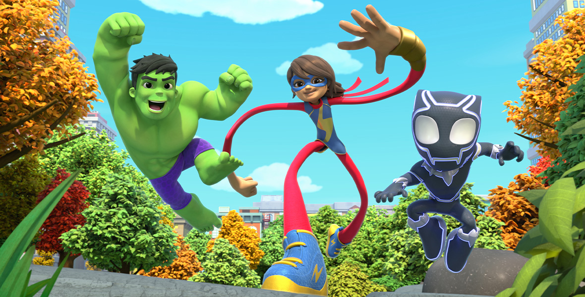 Animated characters Hulk, Ms. Marvel, and Black Panther sprint forward. Hulk is all-green and wears purple shorts. His arms are in the air. Ms. Marvel wears a red and blue Super Hero suit and stretches her limbs to be long. Black Panther wears an all-black Super Hero suit with purple accents. Around them is fall foliage and tall buildings.