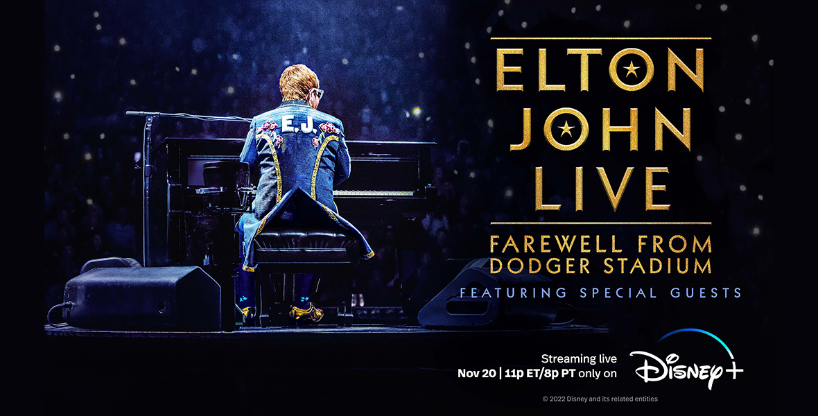 Key art for Disney+ special Elton John Live: Farewell from Dodger Stadium. Musician and Disney Legend Elton John sits at a large, black piano on a stage. He wears a blue suit with “E.J.”, gold stripes and red roses embroidered on the back. To the right reads “ELTON JOHN LIVE: FAREWELL FROM DODGER STADIUM FEATURING SPECIAL GUESTS.” Below is the Disney+ logo and “Streaming Live Nov. 20 11 p.m. ET/8 p.m. PT.”