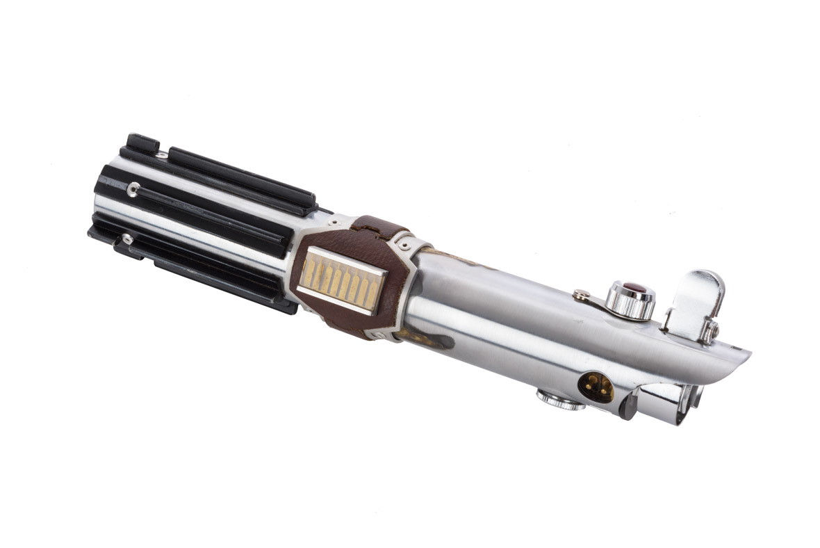 A photo depicts the hilt of a lightsaber used in the film Star Wars: The Rise of Skywalker, one of the historical artifacts that will be included in Disney100: The Exhibition. The lightsaber hilt has been photographed against a neutral white background.