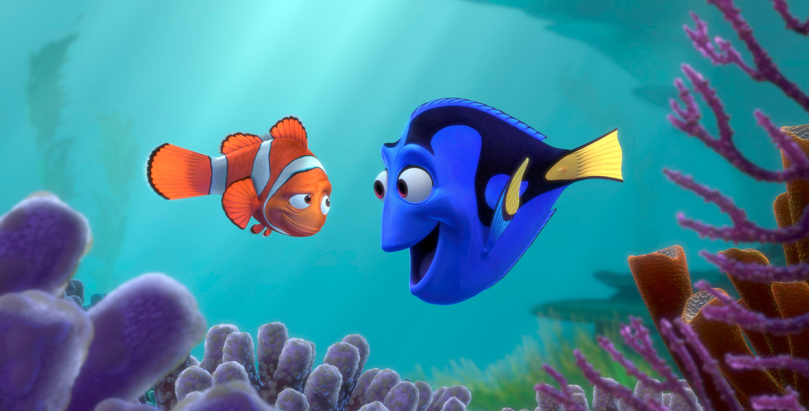 In a still from 2003’s Finding Nemo, Marlin the clownfish (on the left) is talking to Dory the blue tang fish (on the right). There are corals surrounding them.