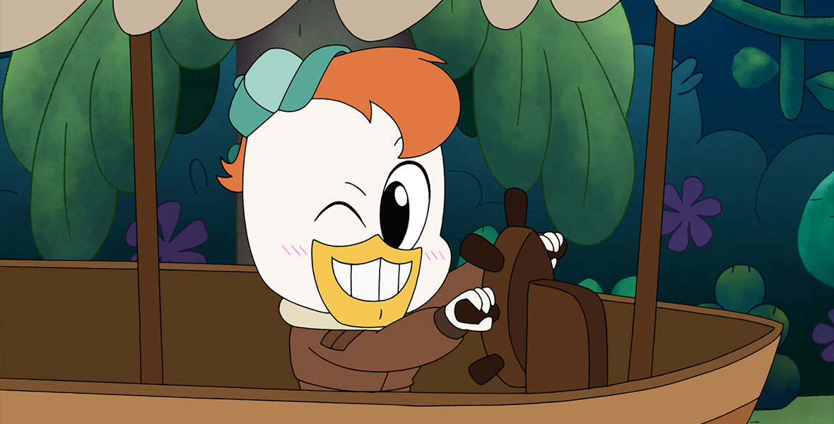 In a still from the animated series Chibi Tiny Tales, Launchpad McQuack, an animated duck from the series DuckTales, steers a small riverboat and winks his right eye. He wears a small green baseball cap on his head and a brown jacket. He has orange hair and white feathers. Behind him are lush green foliage. The boat has a tan canopy and is constructed with brown wood.