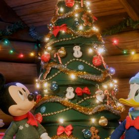 In this scene from Mickey Saves Christmas are, from left to right, Minnie Mouse, Mickey Mouse, Donald Duck, Goofy, and Daisy Duck, all gathered at the base of a Christmas tree. The characters are in winter garb, and the room they’re in is decorated with lights and pine garland on the log walls.