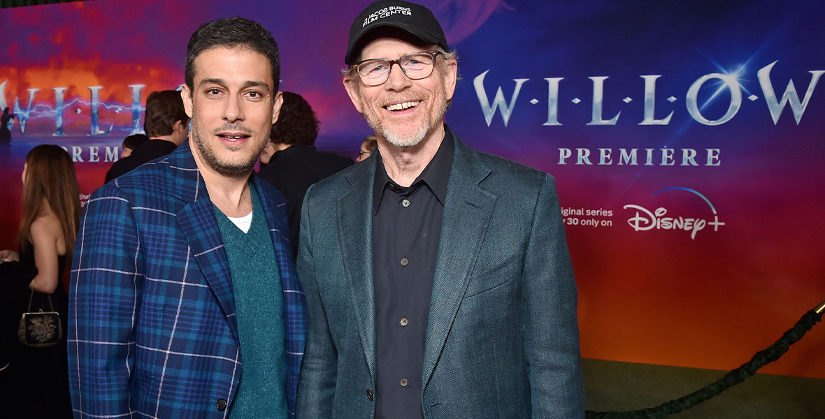 Creator and showrunner Jonathan Kasdan with executive producer Ron Howard. Kasdan is wearing a blue plaid blazer, teal sweater, and matching plaid pants. Howard is wearing a gray suit jacket with black button-up shirt and black pants. He is also wearing a black baseball cap that reads, “Jacob Burns Film Center.”