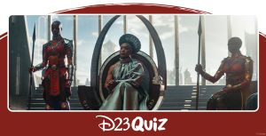 Ramonda, mother of T’Challa, sits on a throne in a silver dress and a circular silver headpiece.