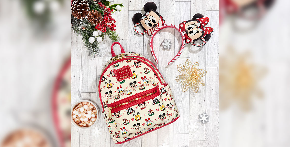 A backpack with a repeating pattern of hot cocoa mugs designed to look like Mickey, Minnie, Donald, Daisy, Pluto, Chip, and Dale. To the left of the backpack is a mug of hot cocoa. To the right of the backpack is a Mickey ears headband, where the ears are designed to look like Mickey and Minnie hot cocoa mugs.