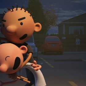 Rodrick has spikey hair and is holding Greg in his left arm while rubbing his head with his right fist.