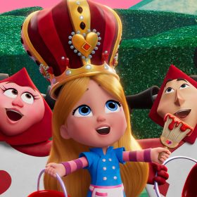 Alice is in the center of a garden, flanked by two black and red Card Guards on each side. Alice wears a blue jacket and a pink apron over a purple and pink striped long-sleeved shirt. Alice wears a tall gold crown with red and maroon fabric, adorned with diamonds, rubies, and red hearts. She holds a red paint bucket with a purple handle in her right hand and a paintbrush with red paint dripping off of it in her left.