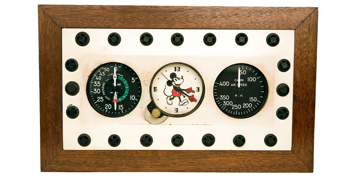 A panel from Walt’s plane featuring pressure and air speed monitors flanking a Mickey Mouse clock.