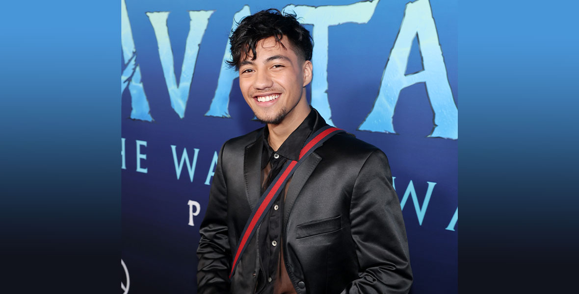 Duane Evans Jr. poses in front of the Avatar: The Way of Water step and repeat.
