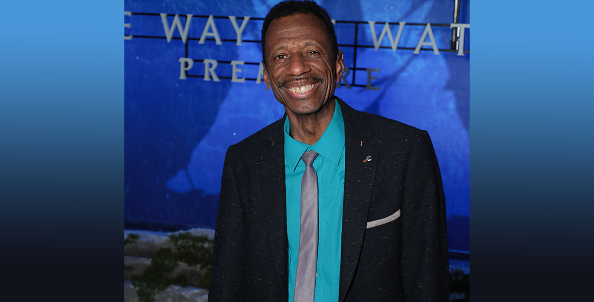 CJ Jones stands in front of a sign for Avatar: The Way of Water