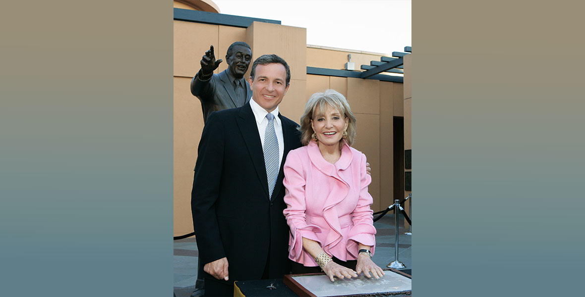 Bob Iger, CEO of The Walt Disney Company, stands next to Barbara Walters as she presses her hands into plaster as part of the Disney Legends ceremony on Legends Plaza on the Walt Disney Studios Lot in Burbank in 2008.