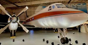 Side view of Walt&rsquo;s Plane. Walt&rsquo;s Plane is white with an orange stripe across the middle of the body.